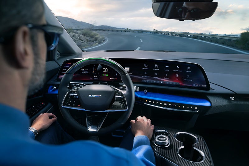 Front View of the 2026 OPTIQ-V Driving Through the Dusk Utilizing its Headlights | Earnhardt Cadillac in Scottsdale AZ