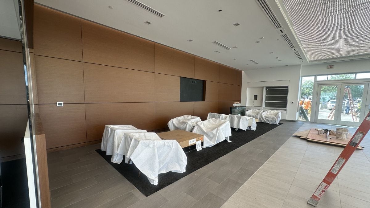 New customer lounge at Earnhardt Cadillac with wood panel wall and covered seating during renovation
