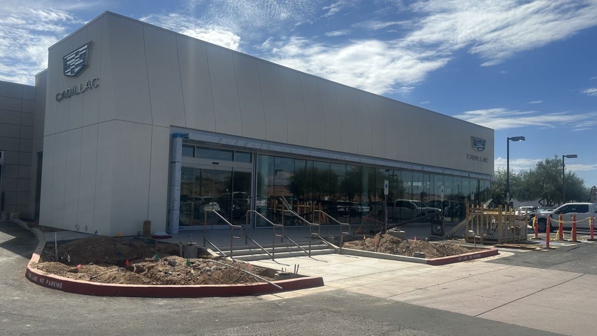 Exterior of the Earnhardt Cadillac showroom in Scottsdale with new glass storefront and landscaping work underway