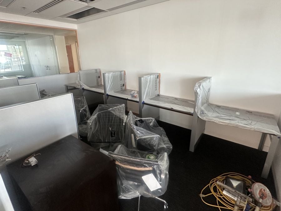 New office workstations and chairs wrapped in plastic at Earnhardt Cadillac during renovation